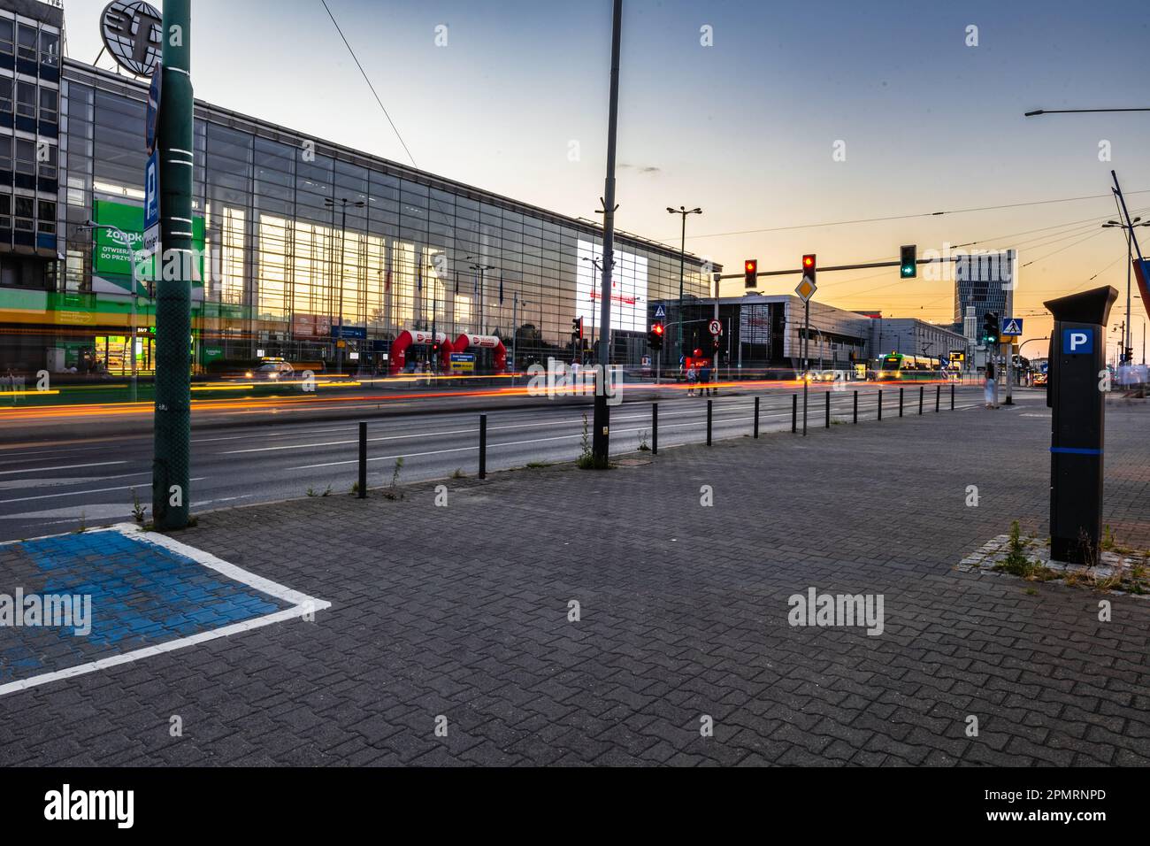 Poznan, Poland - July 2022: A busy intersection in front of the entrance to the Poznan International Fair after sunset Stock Photo