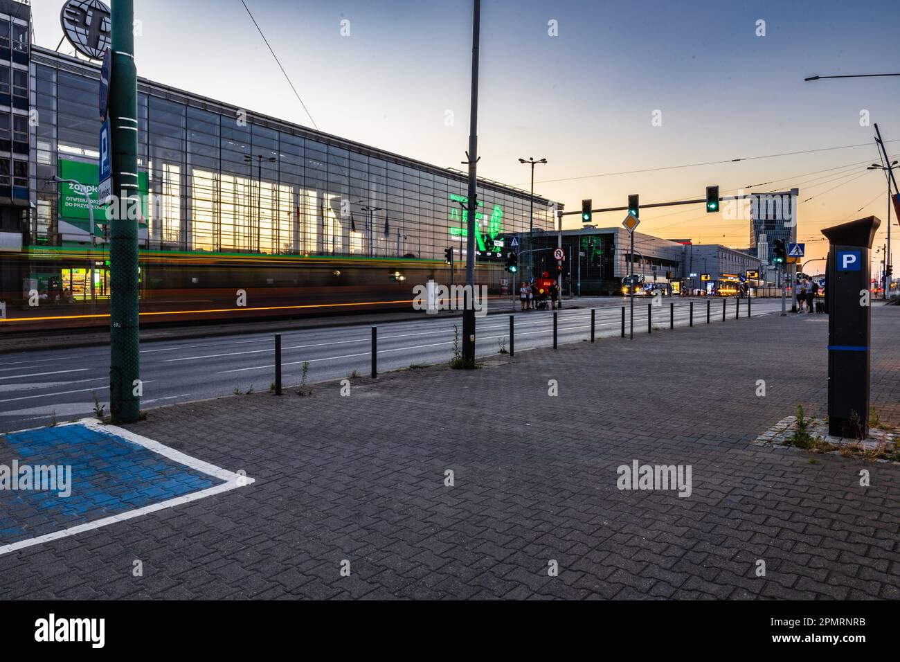 Poznan, Poland - July 2022: A busy intersection in front of the entrance to the Poznan International Fair after sunset Stock Photo