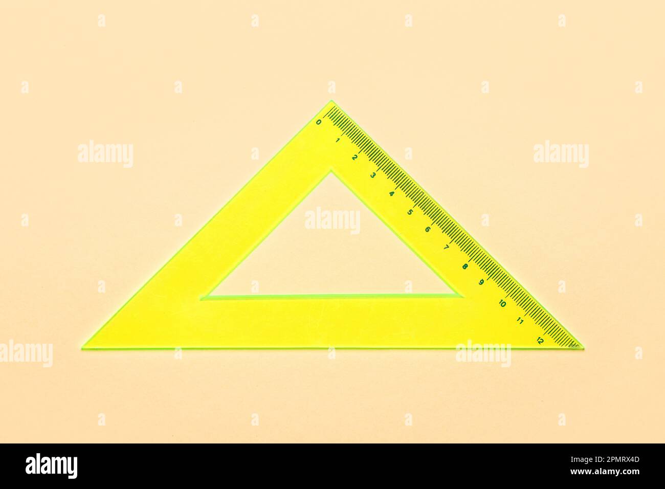 Yellow triangle plastic ruler on beige background Stock Photo - Alamy