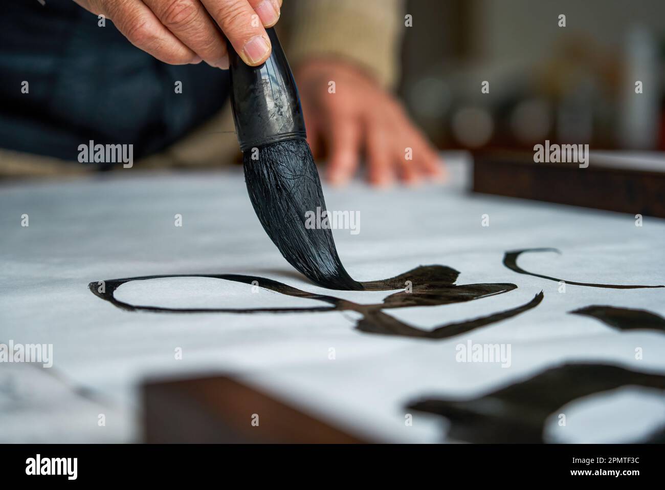 An old Chinese calligrapher is creating and writing calligraphy works. Translation carry on the