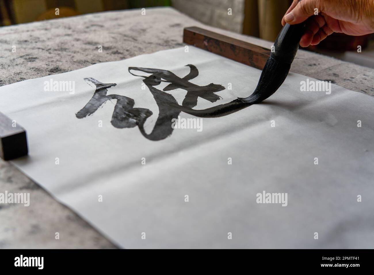 An old Chinese calligrapher is creating and writing calligraphy works. Translation carry on the
