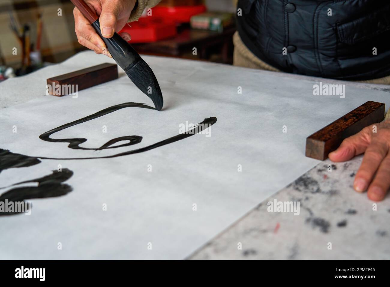An old Chinese calligrapher is creating and writing calligraphy works. Translation carry on the