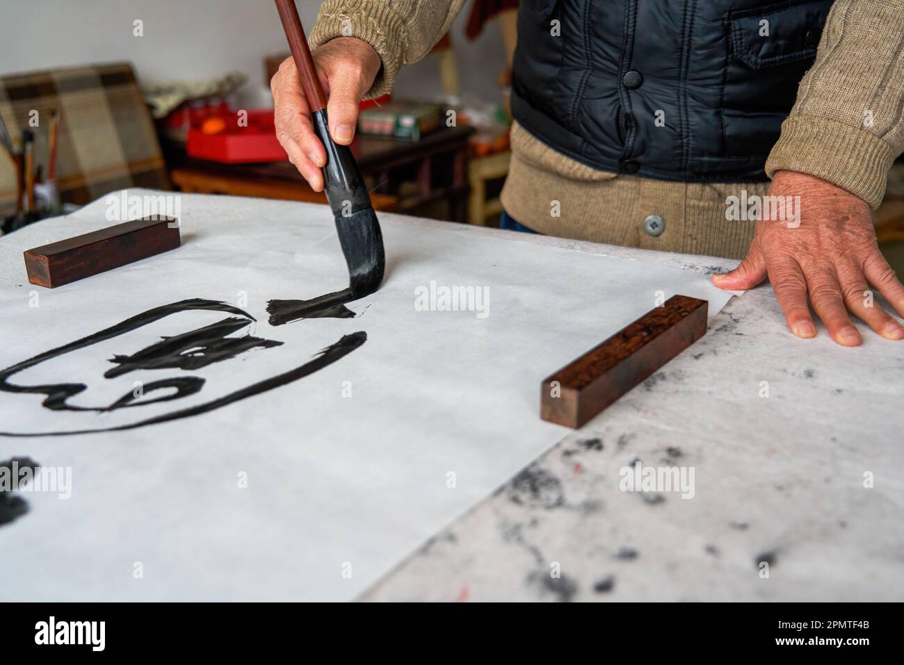 An old Chinese calligrapher is creating and writing calligraphy works. Translation carry on the