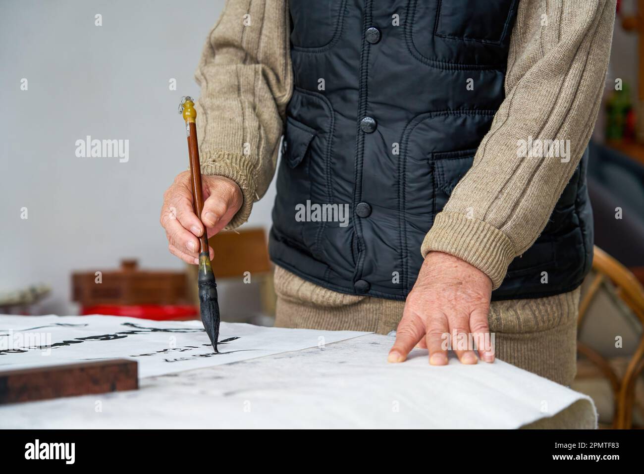 An old Chinese calligrapher is creating and writing calligraphy works. Translation carry on the