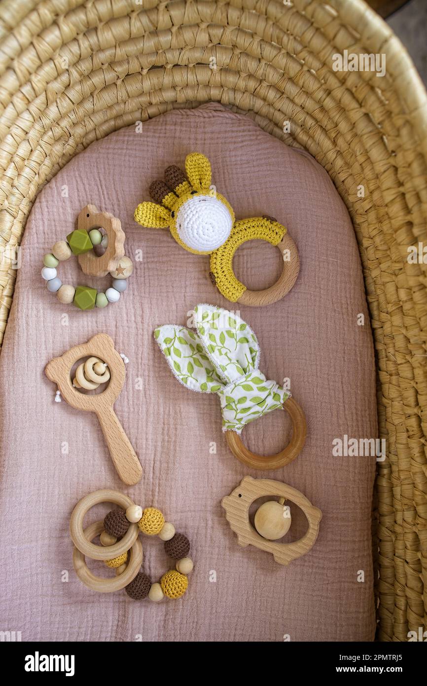 in a basket natural wooden knitted toys for a newborn. View from above. Stock Photo