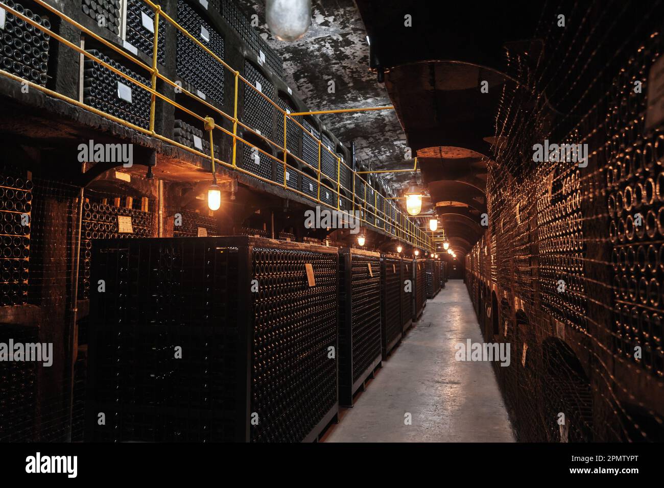 Winery interior perspective view, dark corridor with stacked bottles Stock Photo