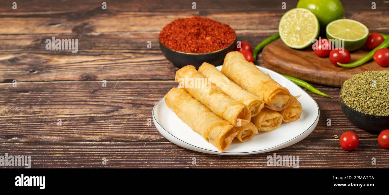 Cigarette pastry. Cheese pie on wood floor. Fried cheese rolls with phyllo. Local name sigara boregi. Empty space for text. copy space Stock Photo