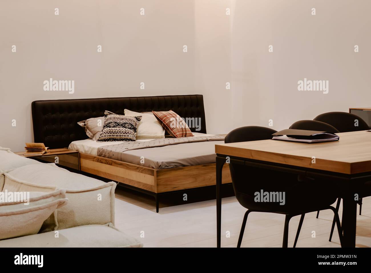 Double bed with pillows and a table for working in the bedroom Stock