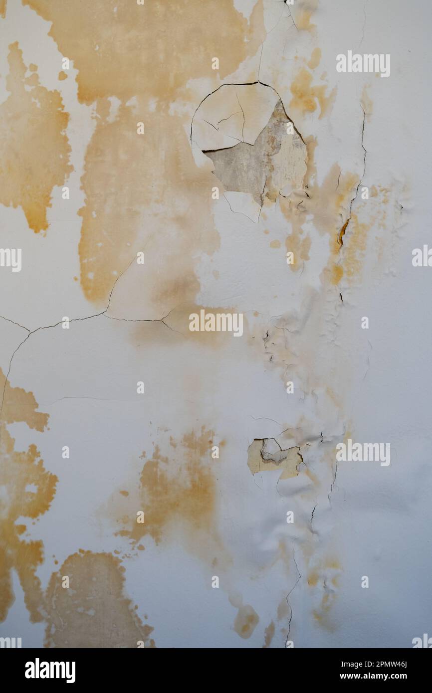 Leaky roof dampness in room ceiling. Yellow rusty spots with chipped