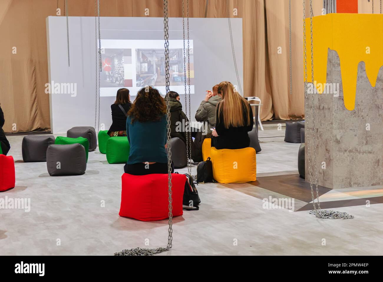 Lounge zone. People at the presentation sit in front of the protector screen on soft ottomans. Stock Photo