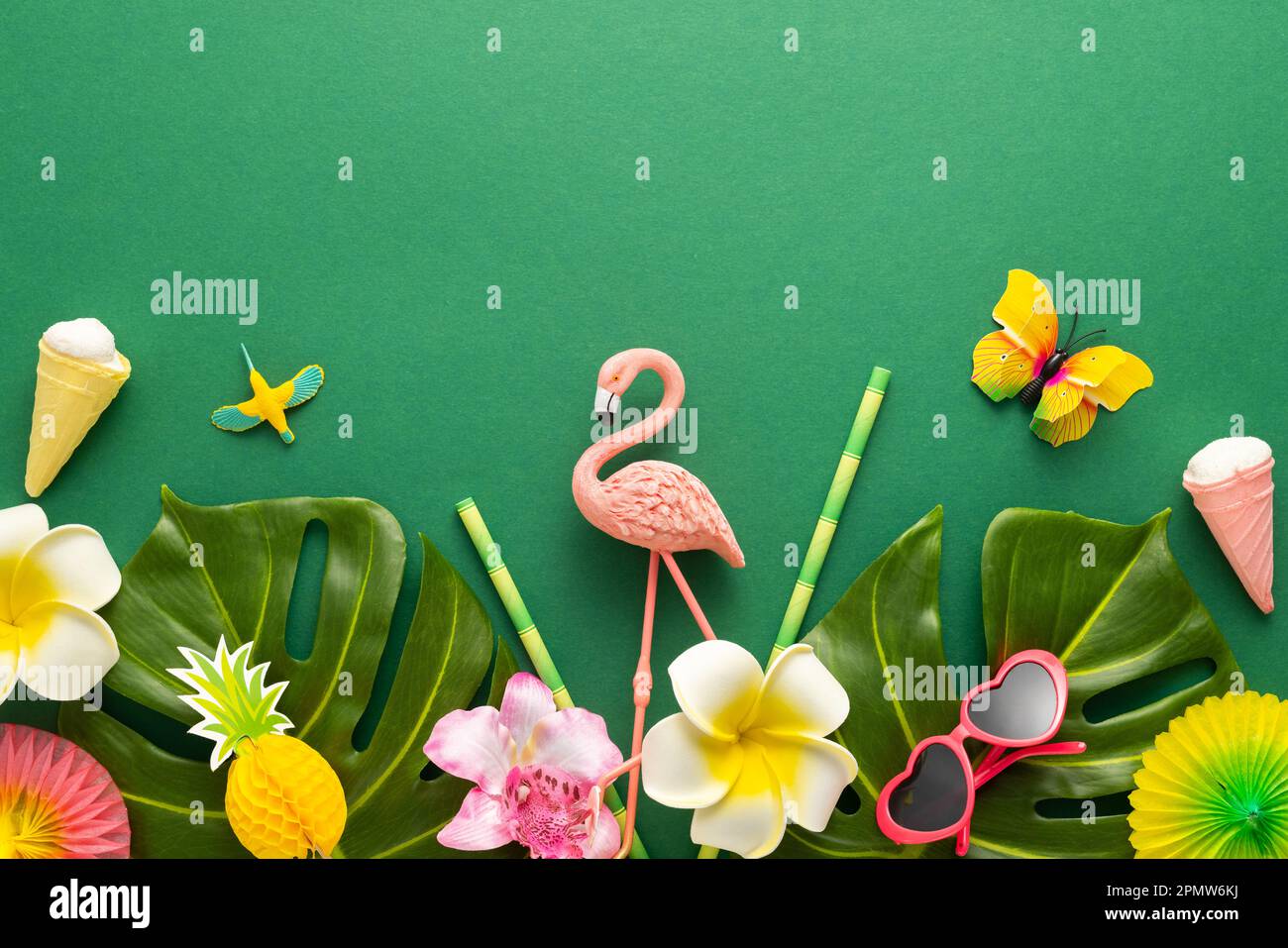 Exotic tropical summer background. Summer beach party concept. Pink flamingo, tropical leaves, orchid flowers and other accessories on green backgroun Stock Photo
