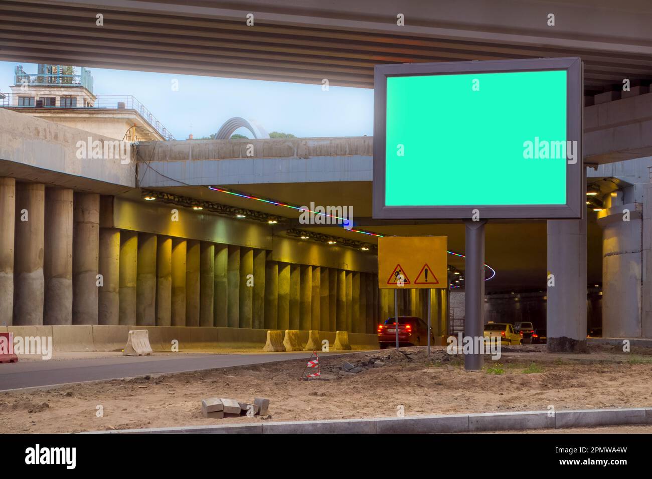 Billboard with a green background, Mock up. The scene under the concrete structure of the road bridge, the interchange in the city. Stock Photo