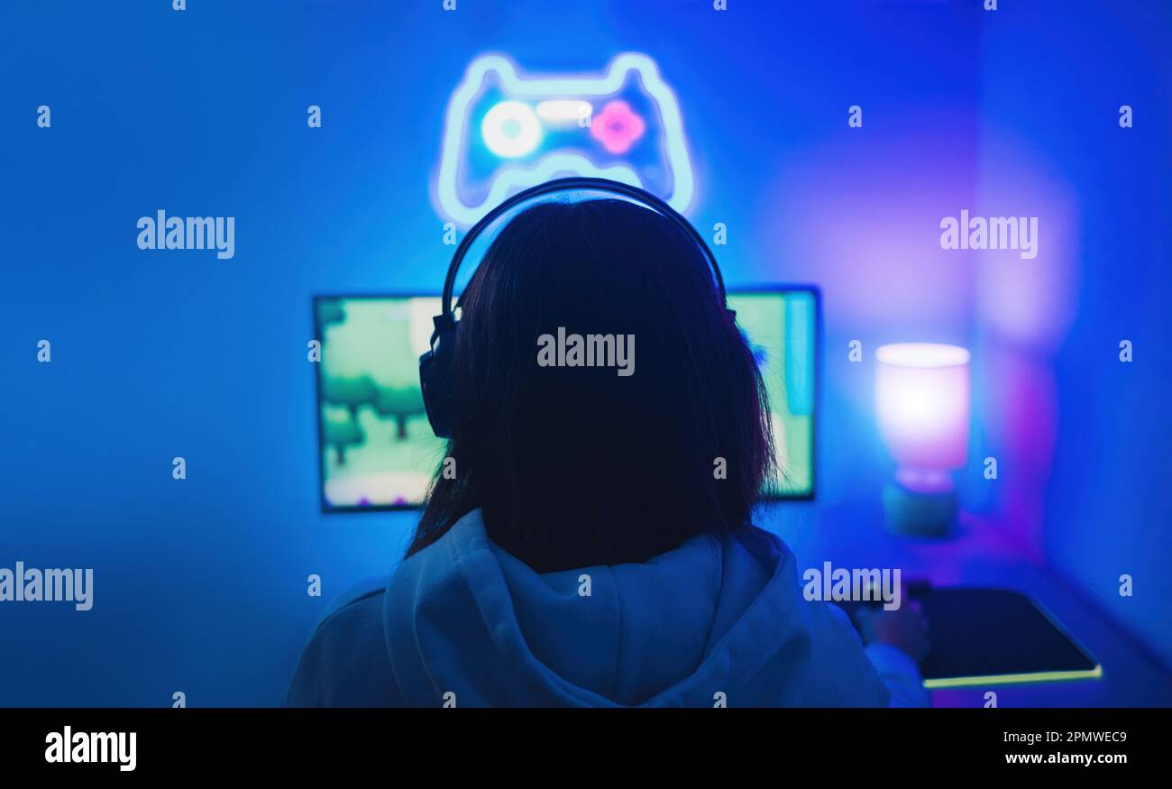 Gamer playing video games on computer at gaming room - Focus on girl ...