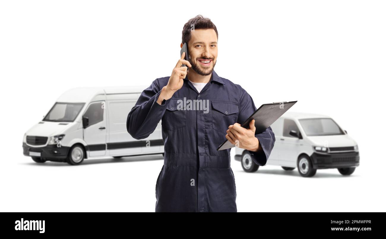 Van driver in a blue uniform using a mobile phone and holding a clipboard isolated on white background Stock Photo