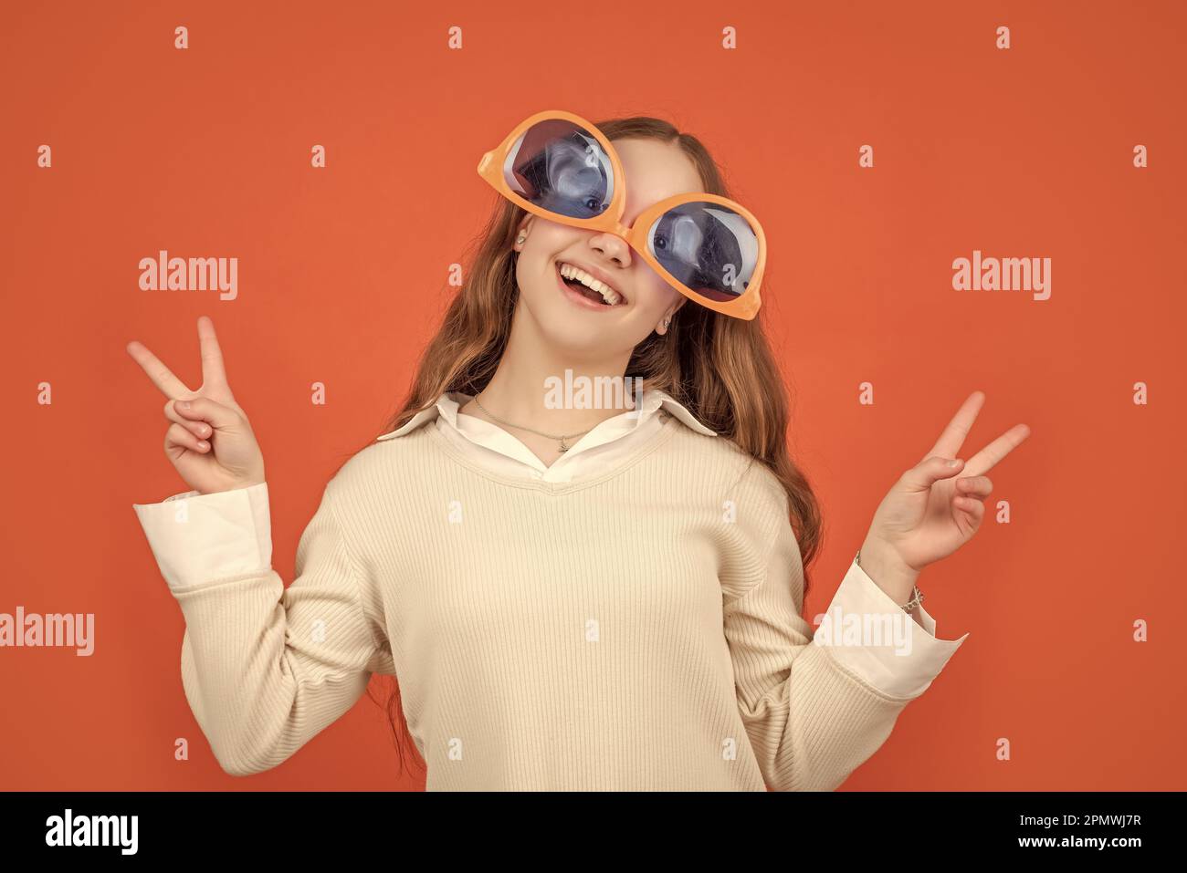 Happy girl wearing big funny sunglasses upsidedown making Vsings