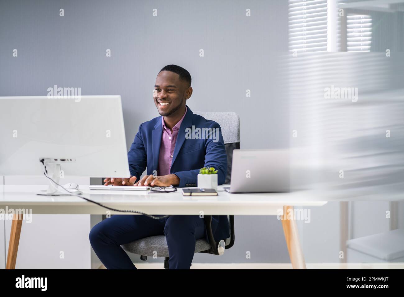 African Businessman Banner Using Computer In Office Stock Photo