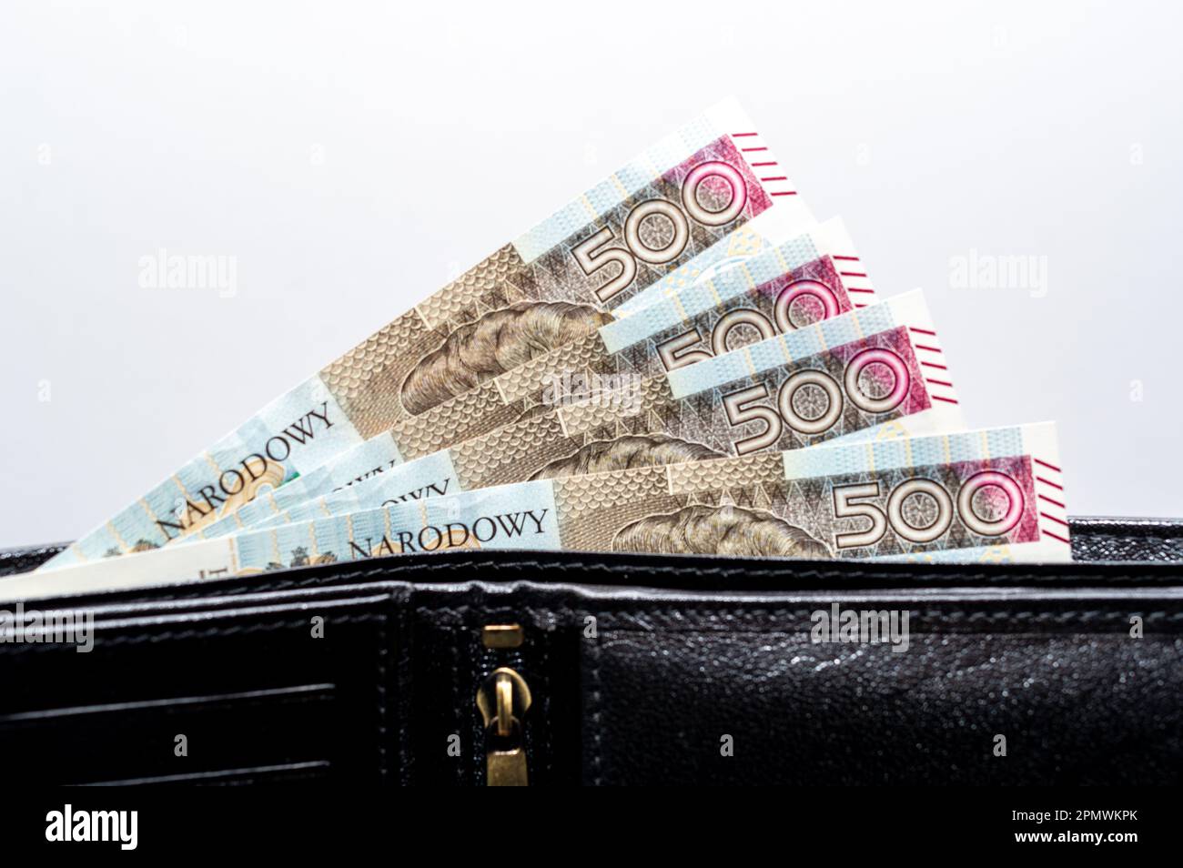 A closeup shot of 500 zloty bills protruding from a leather black wallet Stock Photo