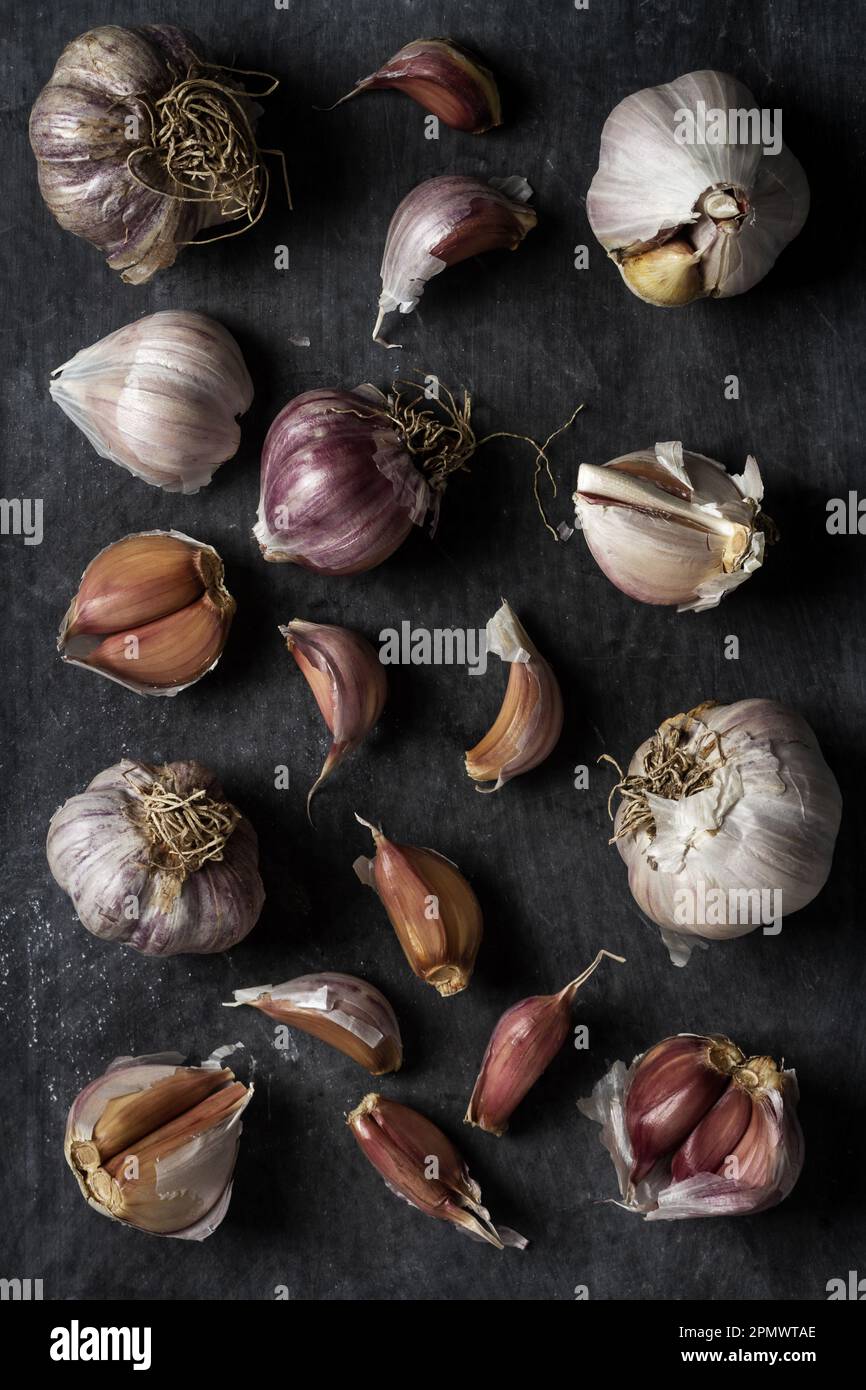 Fresh garlic bulbs and cloves grouped on black background. Flat lay ...