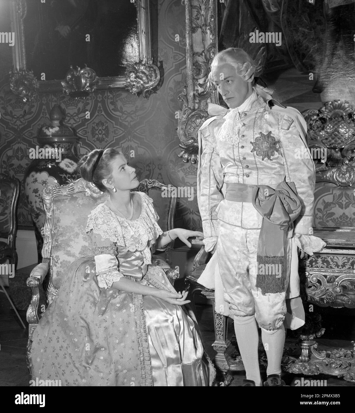As if in the 18th century. Actors Stig Grybe and Maj-Britt Nilsson in a scene taken inside the royal castle Drottningholm in Stockholm. The photograph was originally published to illustrate a historic novel running in several episodes in a magazine 1956. The room, furniture and clothing are typical of the 18th century Sweden. Conard ref EC3168 Stock Photo