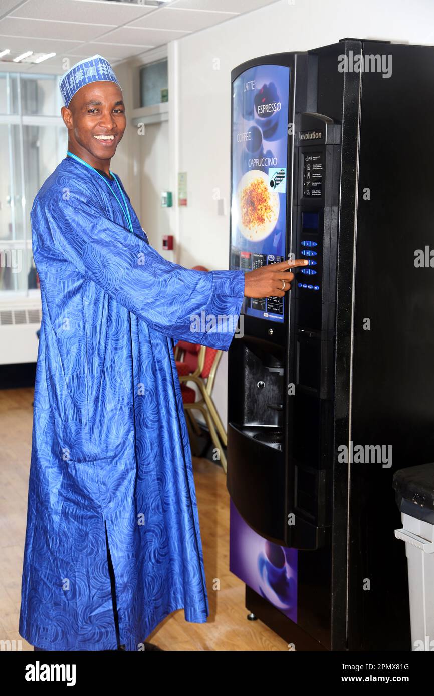Nigerian Man Wearing Traditional Dress Ordering Coffee from Vending