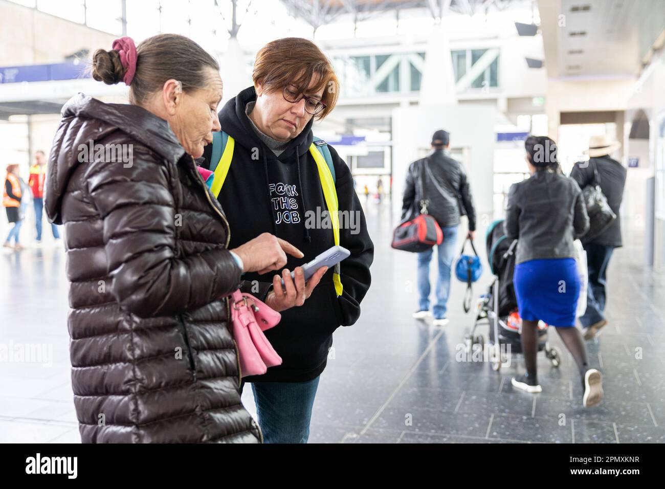 Laatzen, Germany. 15th Apr, 2023. Diana (r), volunteer translator, helps Angela (53, l), refugee from Ukraine, with her onward journey after her arrival at the Laatzen trade fair train station. Around 180 refugees have arrived at Messebahnhof in Laatzen on a final special train. Since the beginning of November 2022, the state of Lower Saxony has fulfilled its reception quota for Ukrainians seeking protection and has since been redirecting new arrivals at the 'Messe/Laatzen' hub to other federal states. Credit: Michael Matthey/dpa/Alamy Live News Stock Photo