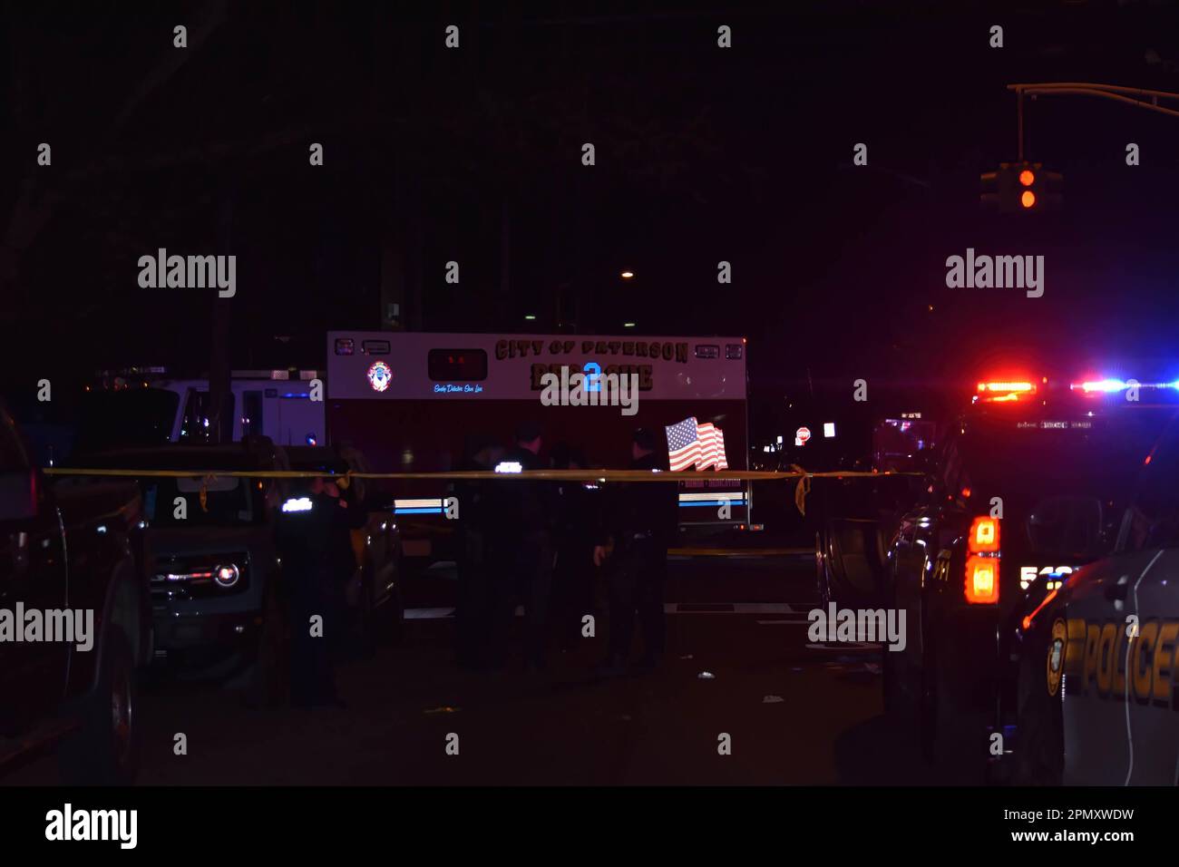 Police officers gather in the area of East 22nd Street. Four people reported shot in a shooting in Paterson, New Jersey, United States in the early morning hours of Saturday, April 15, 2023. Reportedly, four people were shot early Saturday morning after 12:00 AM in Paterson, some of the victims were transported by EMS and some victims were transported by private vehicles. No further information was immediately available from the Paterson police department. There are several crime scenes. One crime scene in the area of East 22nd Street had a vehicle stopped with several investigators and police Stock Photo