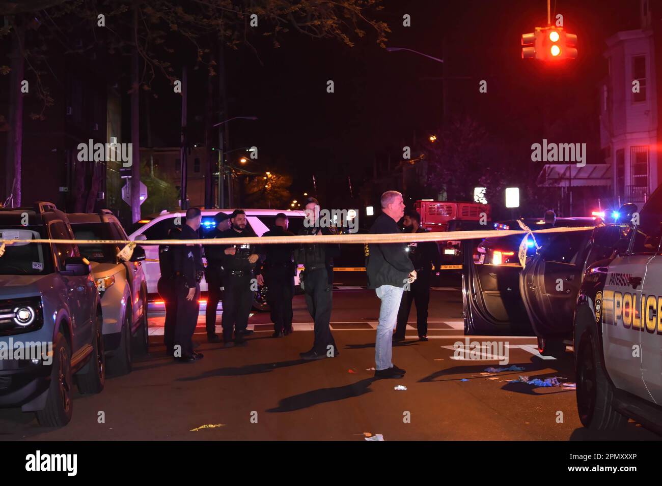Paterson, USA. 15th Apr, 2023. Police officers gather in the area of East 22nd Street. Four people reported shot in a shooting in Paterson, New Jersey, United States in the early morning hours of Saturday, April 15, 2023. Reportedly, four people were shot early Saturday morning after 12:00 AM in Paterson, some of the victims were transported by EMS and some victims were transported by private vehicles. No further information was immediately available from the Paterson police department. There are several crime scenes. One crime scene in the area of East 22nd Street had a vehicle stop Stock Photo