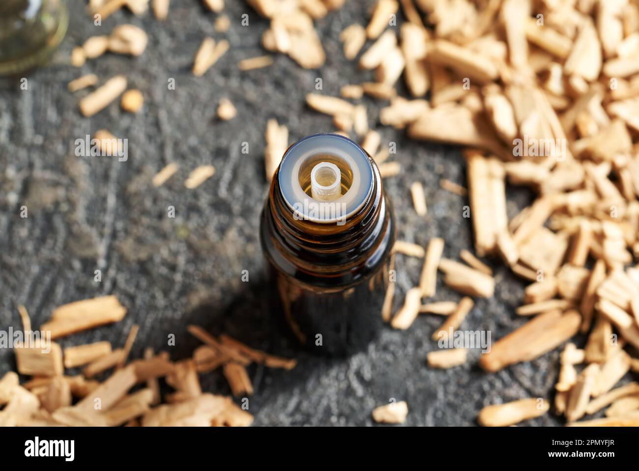 Essential oil bottle with white sandalwood chips on a table Stock Photo