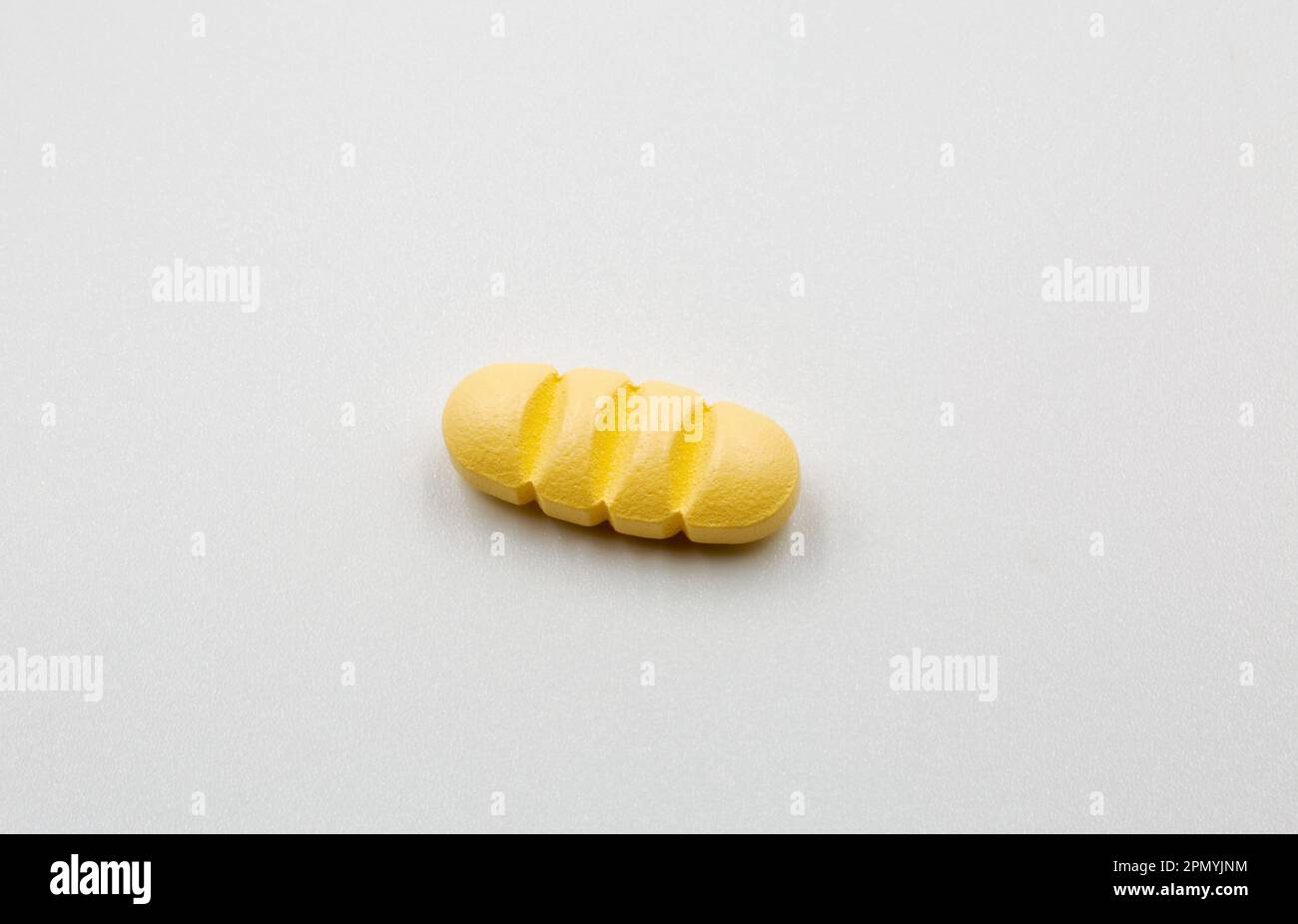 Yellow oblong tablet with dividing strips for dividing into four parts