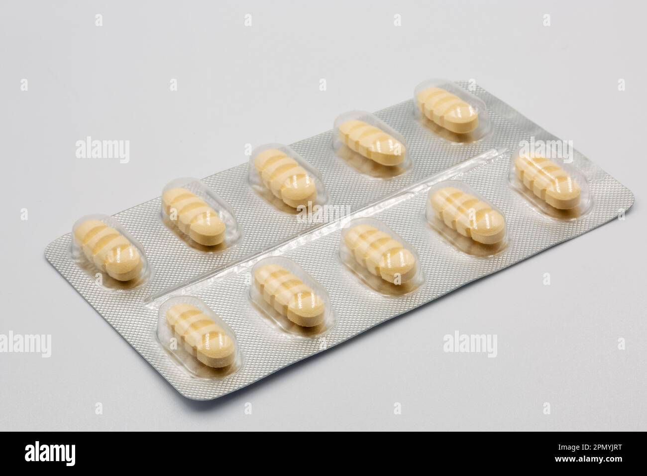 Blister with yellow oblong tablets with dividing strips for dividing