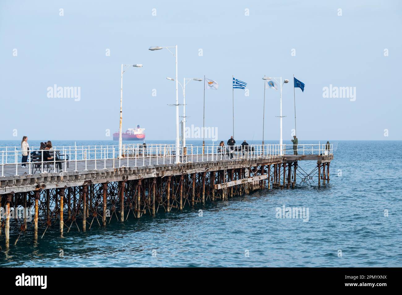 Limassol, Cyprus - March 23, 2023 - Diagonal view over the wooden pier at the old harbour with Greek, Cypriot and European flags Stock Photo