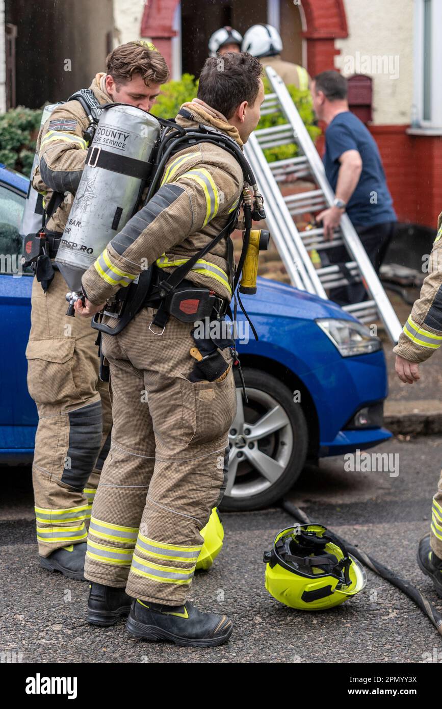Essex County Fire & Rescue Service responding to a house fire in Westcliff on Sea, Essex, UK. Firefighters donning breathing apparatus Stock Photo