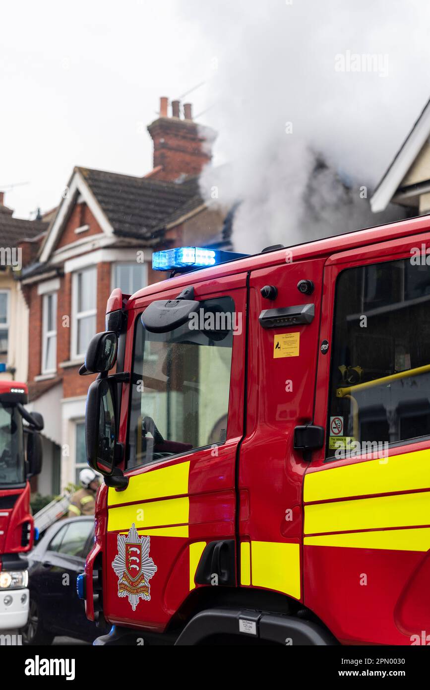 Essex County Fire & Rescue Service responding to a house fire in Westcliff on Sea, Essex, UK. Fire engine on scene with smoke from property Stock Photo