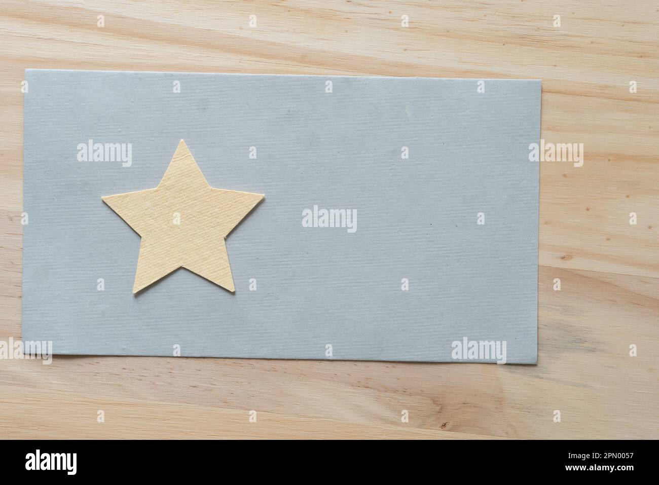 simple paper star on a grey paper backdrop and wood Stock Photo