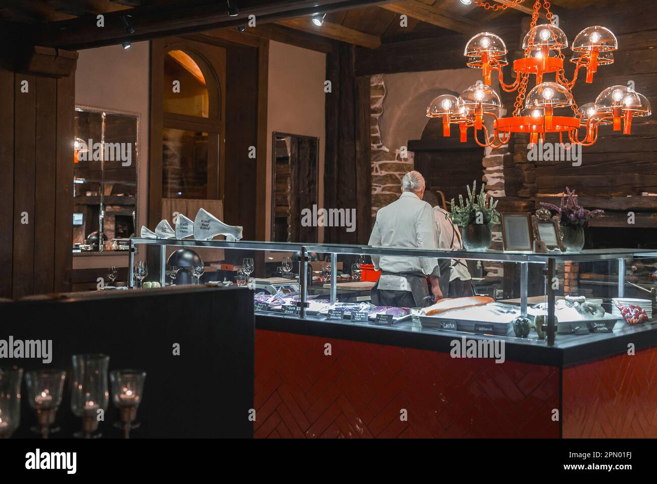 Rear view of male chef working in kitchen at alpine hotel Stock Photo