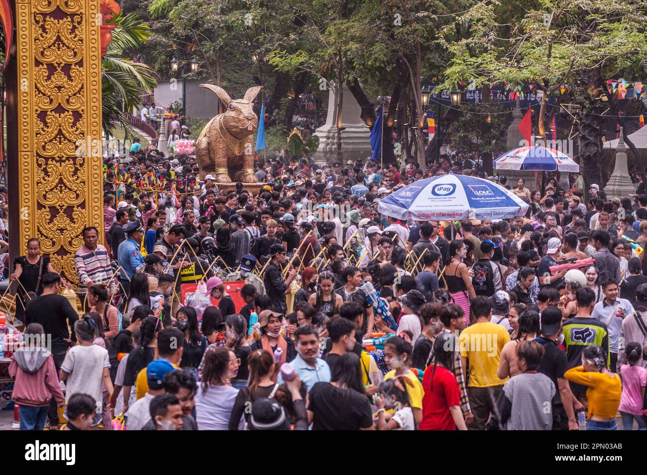 A rattan rabbit sculpture sits above a densely packed crowd during The Cambodian New Year festival. Wat Phnom, Phnom Penh, Cambodia. © Kraig Lieb Stock Photo