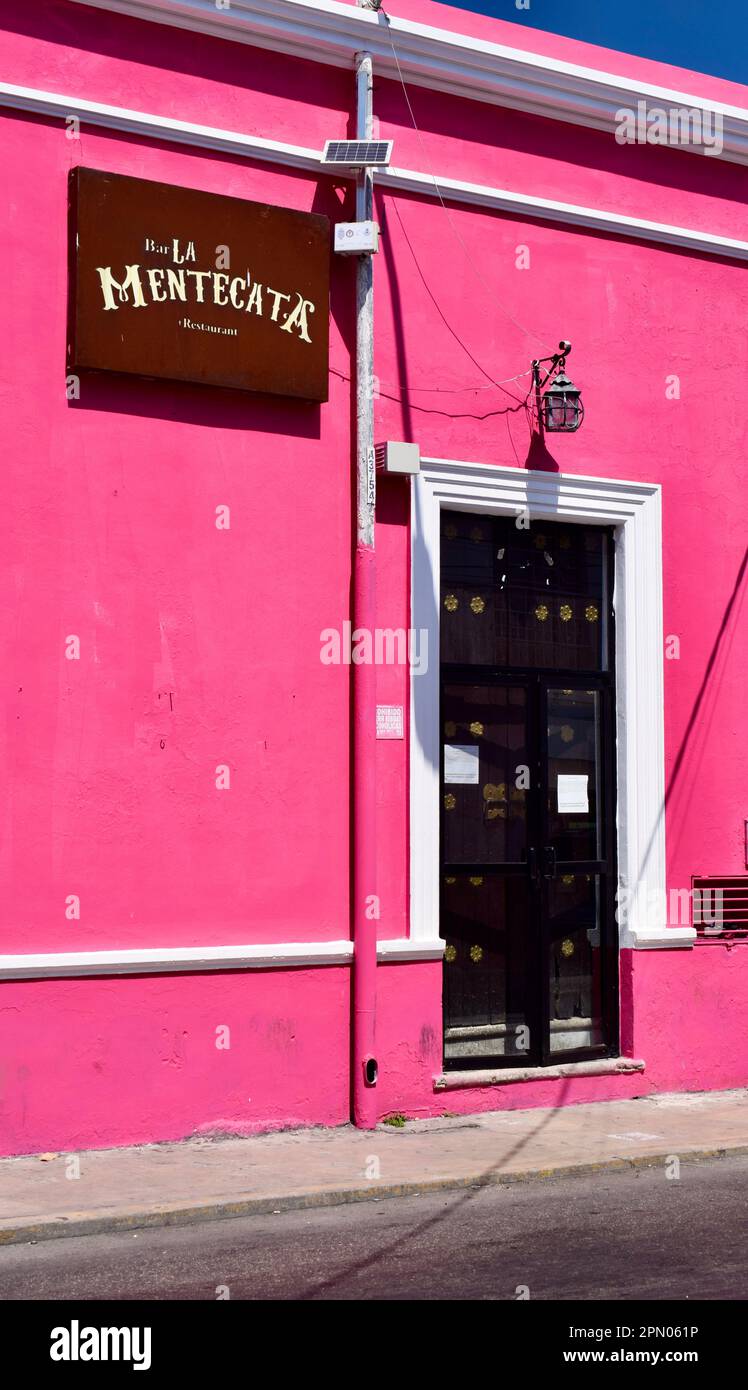 The bright pink facade and wooden door of a restaurant in a street of Merida, Yucatan, Mexico. Stock Photo