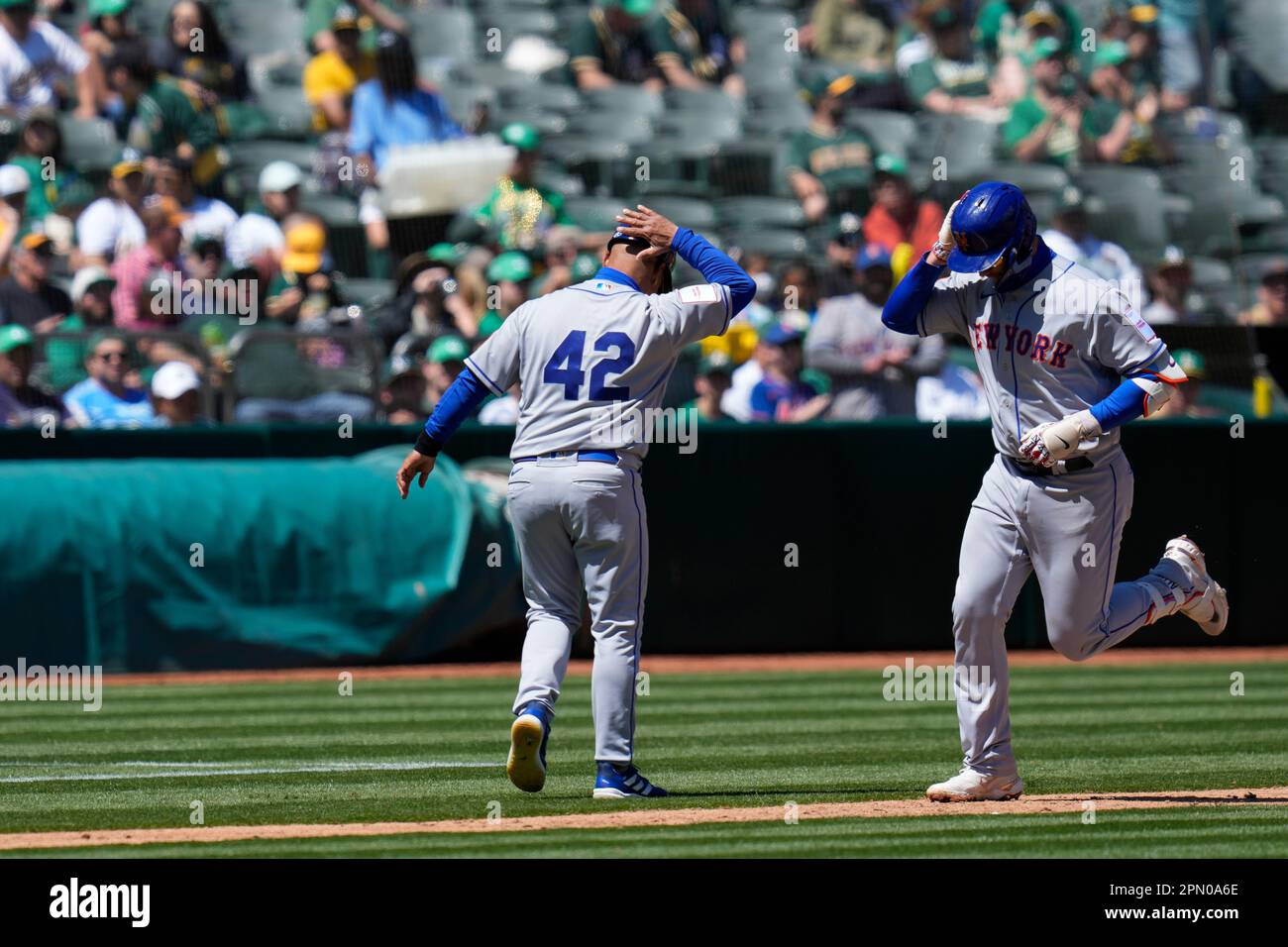New York Mets' Pete Alonso, right, celebrates with infield & third base  coach Joey Cora after hitting a solo home run against the Oakland Athletics  during the fourth inning of a baseball