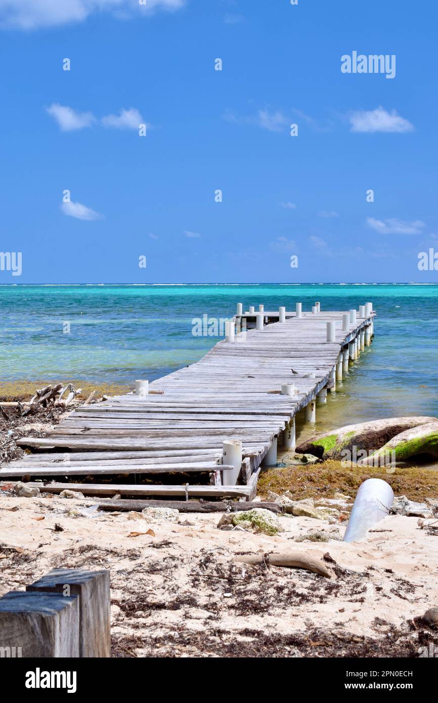 A dock at the beach with the beautiful, turquoise water in the background in San Pedro, Ambergris Caye, Belize, Caribbean/Central America. Stock Photo