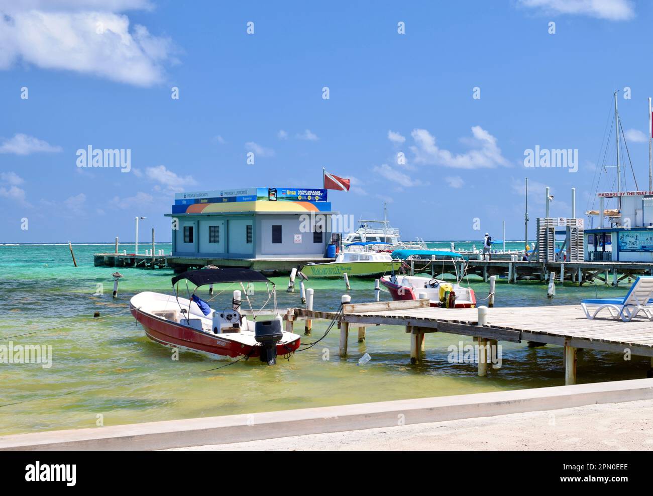 Docked boats over clear water on a sunny day in San Pedro, Ambergris Caye, Belize, Caribbean/Central America. Stock Photo