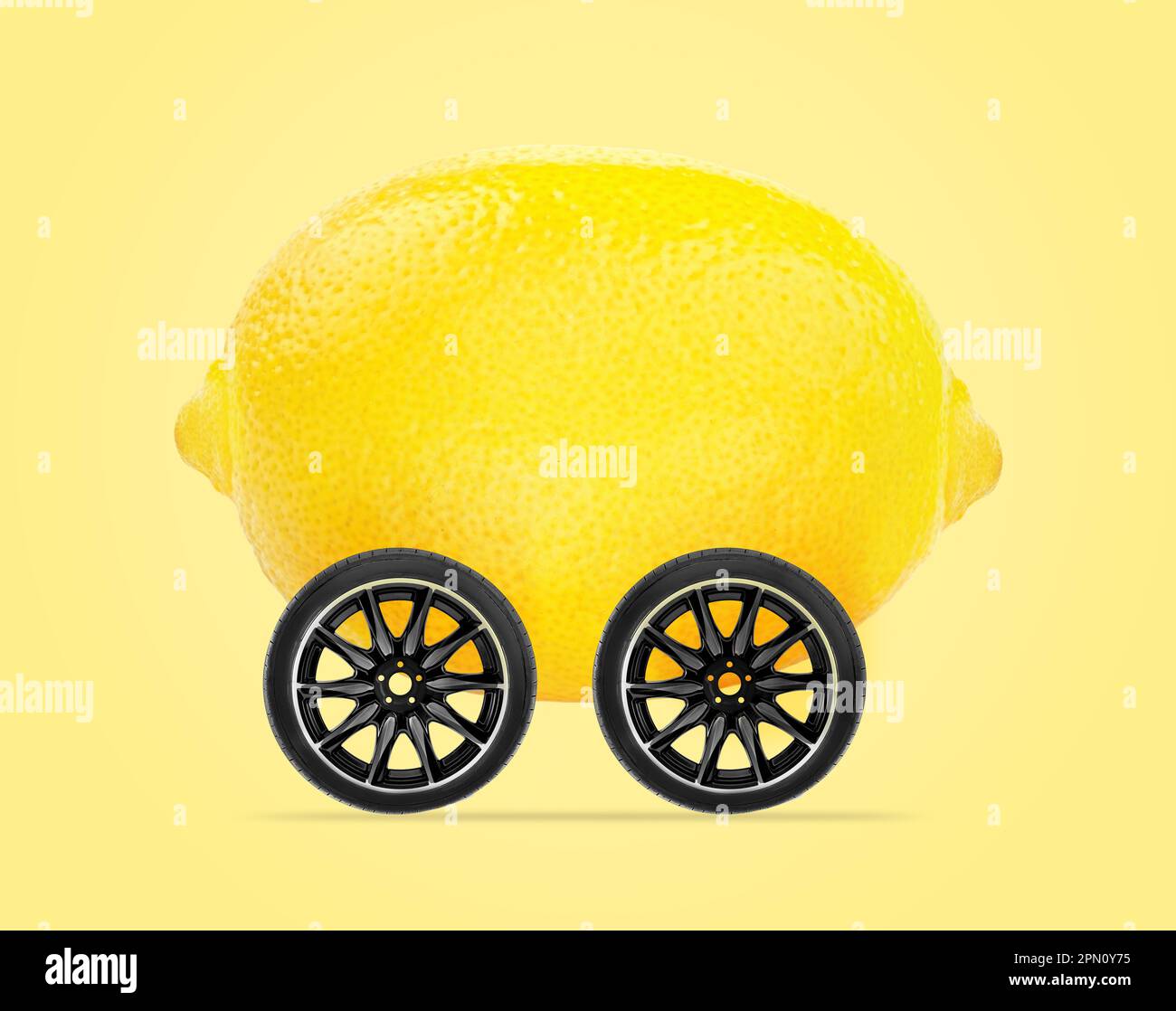 Lemon car concept, lemon with wheels isolated on light yellow