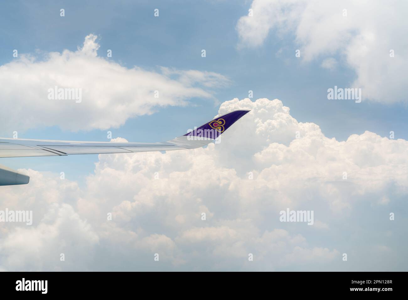BANGKOK, THAILAND-OCTOBER 19, 2019: Plane wing of Thai Airways Airlines. Passenger plane. Wing of plane over white fluffy cumulus clouds. Airplane fly Stock Photo