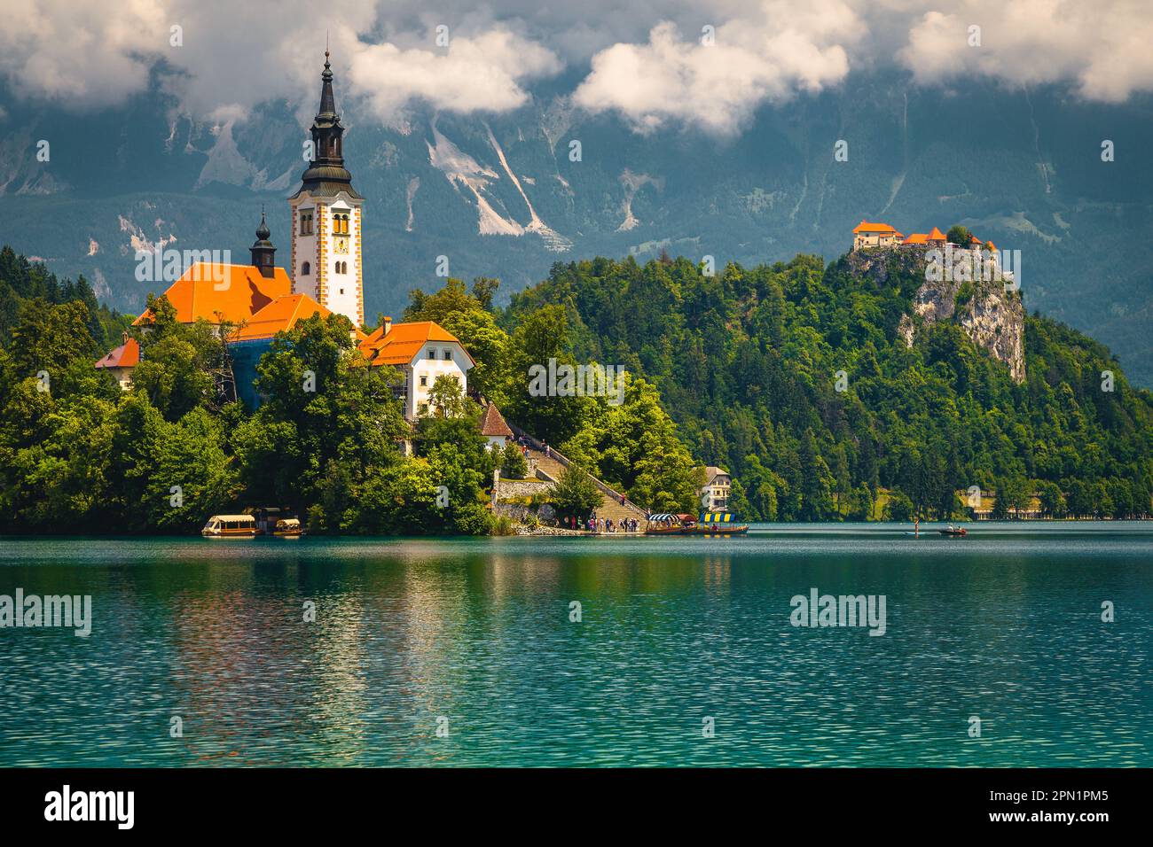 Popular travel destination and boat tours on the lake Bled. Majestic old church on the island and castle on the cliff, Bled, Slovenia, Europe Stock Photo