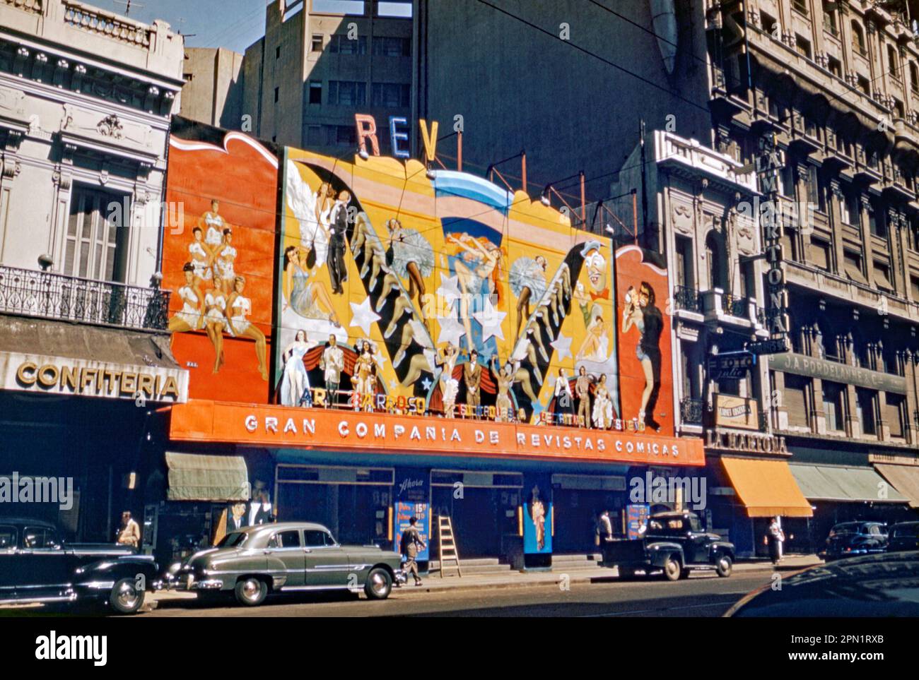 A theatre in downtown Buenos Aires, Argentina, South America putting on a live ‘review’ performance c. 1955. Advertised on a giant colourful hoarding or billboard above the entrance was a variety show by the ‘Gran Compania de Revistas Comicas’ (‘Great Comic Magazine Company’) with ‘leggy’ dancers prominently featured. Star billing went to Ary Barroso (1903–1964), the well-known Brazilian composer and pianist. He was one of the country’s most successful songwriters in the first half of the 20th century, composing many songs for artists like Carmen Miranda – a vintage 1950s photograph. Stock Photo