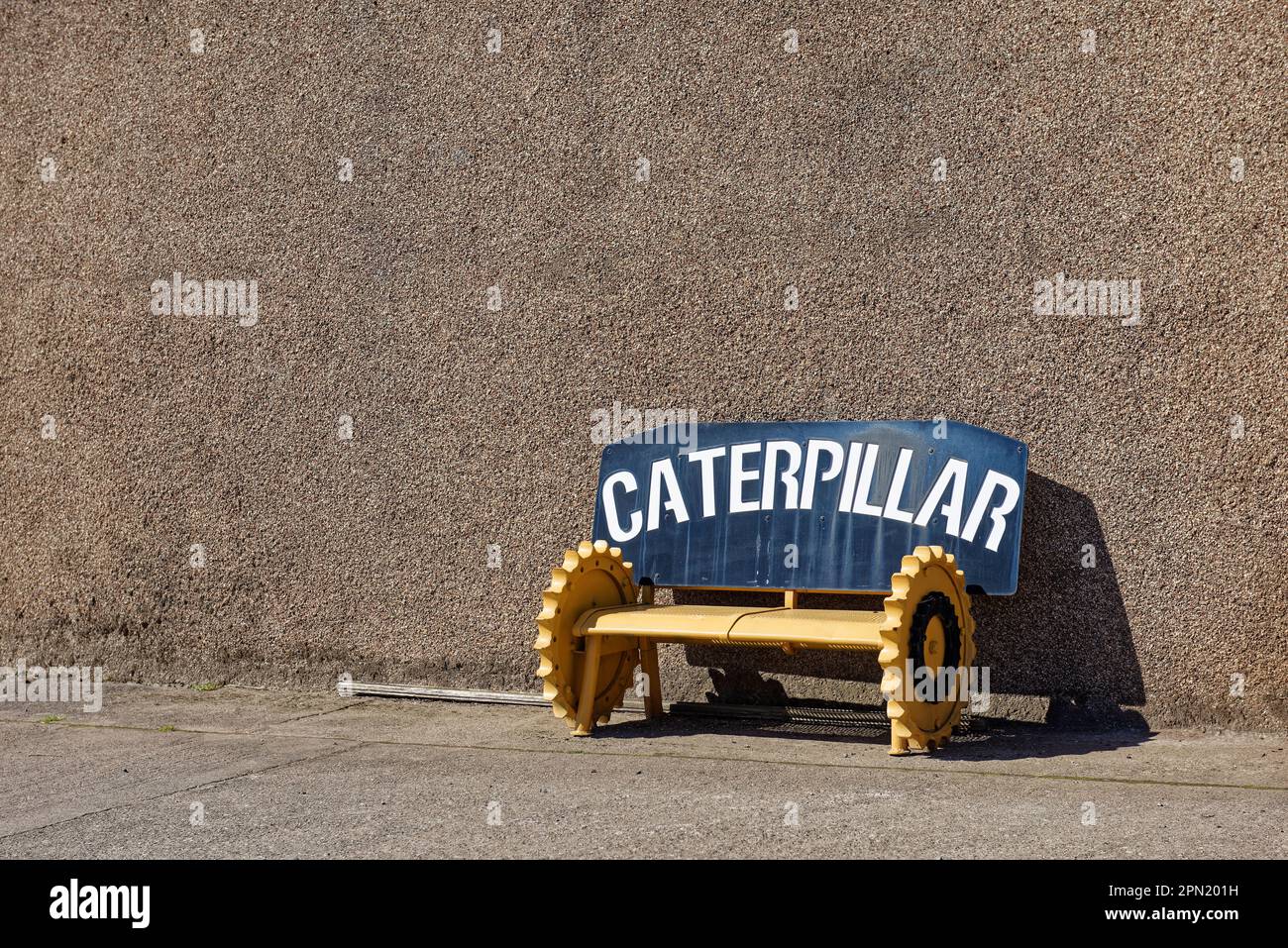 A metal bench made locally from Gear wheels of a tracked Farm Bulldozer on the property of the local haulage company of Geddes. Stock Photo