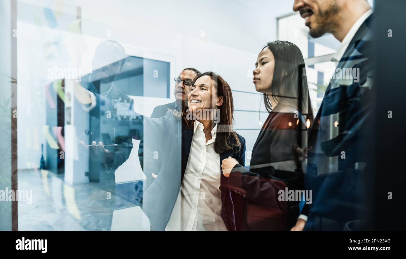 Multiracial creative team planning business market strategy inside boardroom office - Brainstorming and teamwork concept Stock Photo