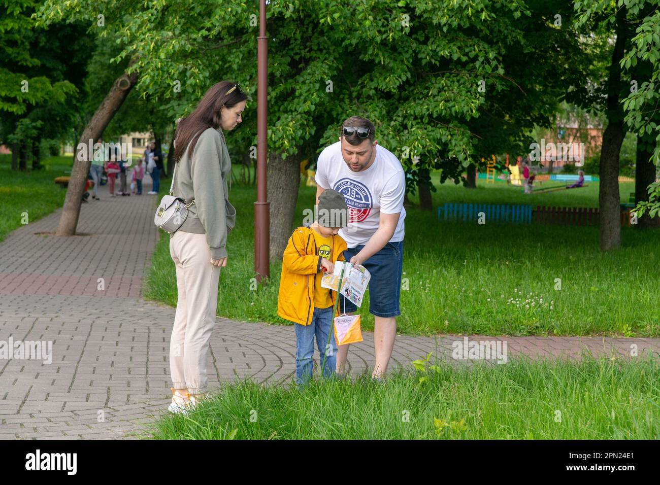 Grodno, Belarus - 15 June, 2022: Training of the Veras orienteering club . A young family of three people at the checkpoint of the route check the map Stock Photo