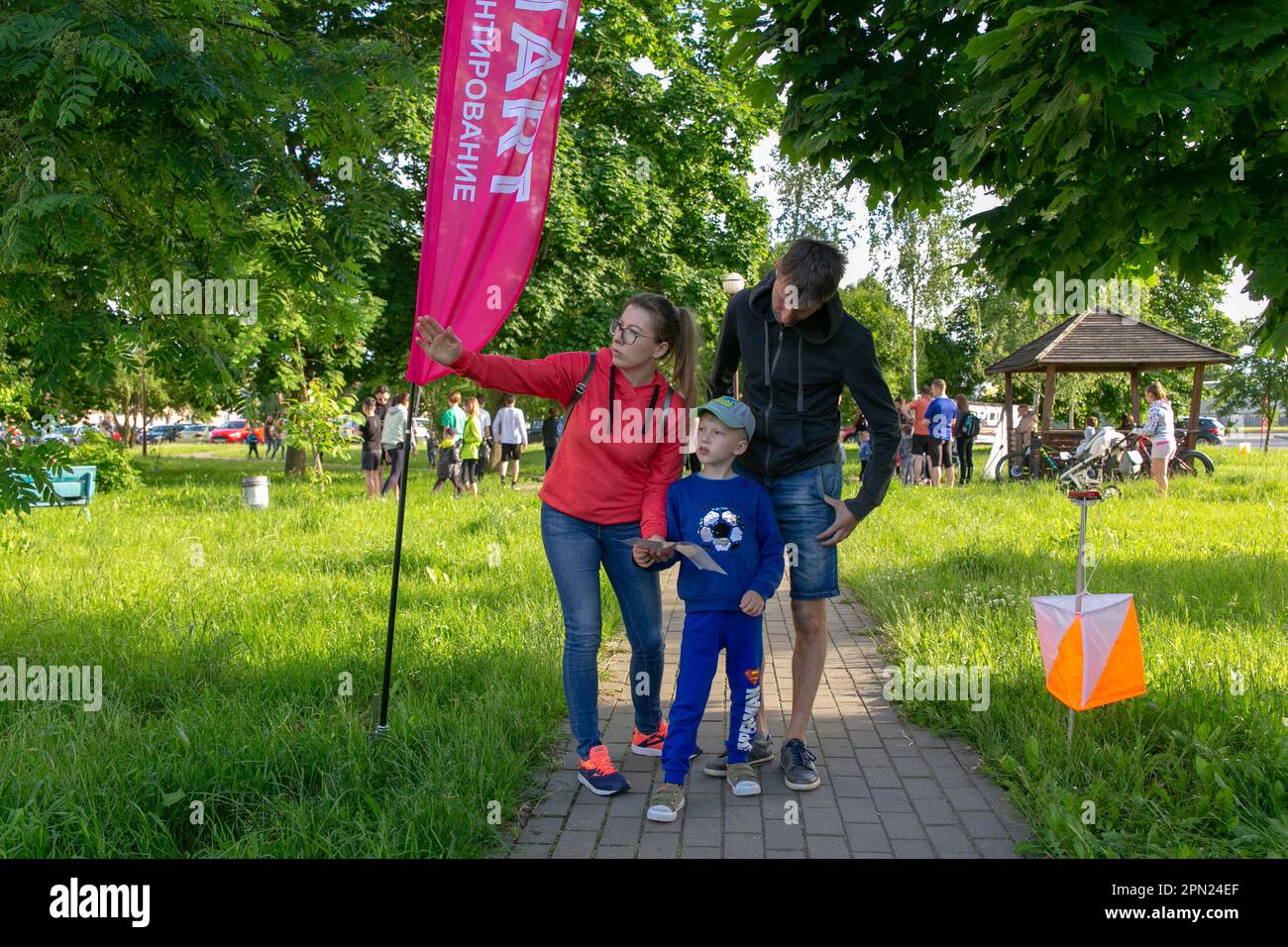 Grodno, Belarus - 15 June, 2022: Training of the Veras orienteering club . A young family of three people at the start of the route check the map and Stock Photo