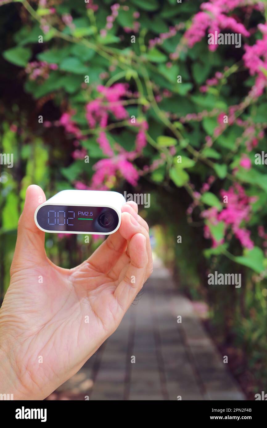 Closeup of hand holding an air pollution sensor measuring air quality