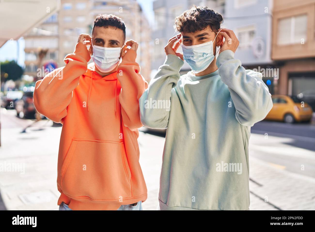 Two man couple wearing medical mask standing together at street Stock ...
